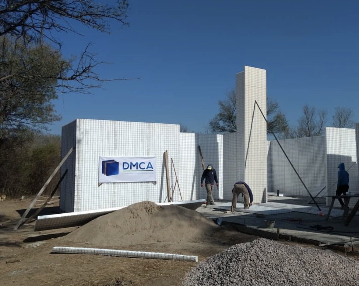 Vivienda en construcción con sistema Emmedue y cartel DMCA en obra